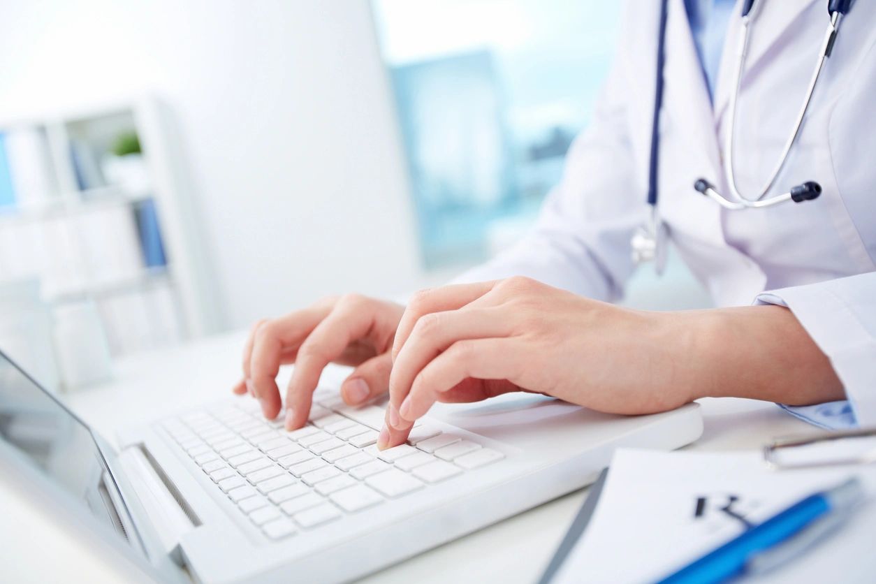 Hands typing on laptop